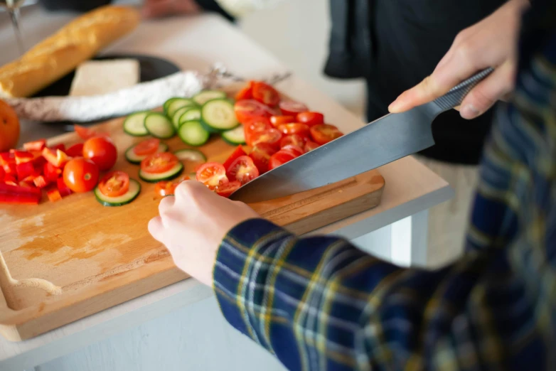 a person  tomatoes on a wooden  board