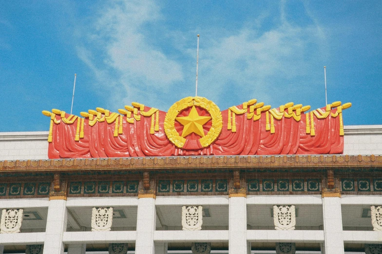 a building with statues on top of it under a cloudy blue sky