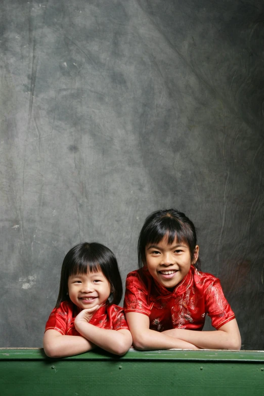 two s sitting on the edge of a bench