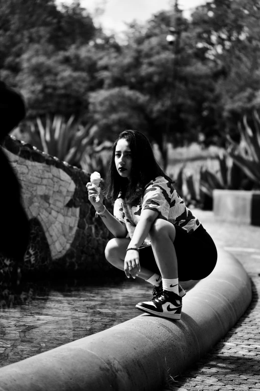 black and white image of woman skateboarding, holding bat