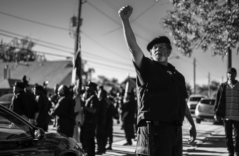 man standing in street with arms raised up