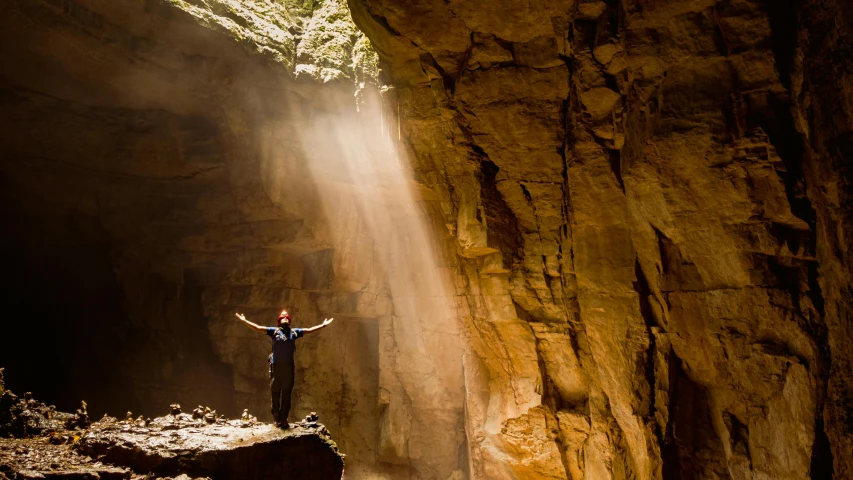 a person standing at the edge of a large cave