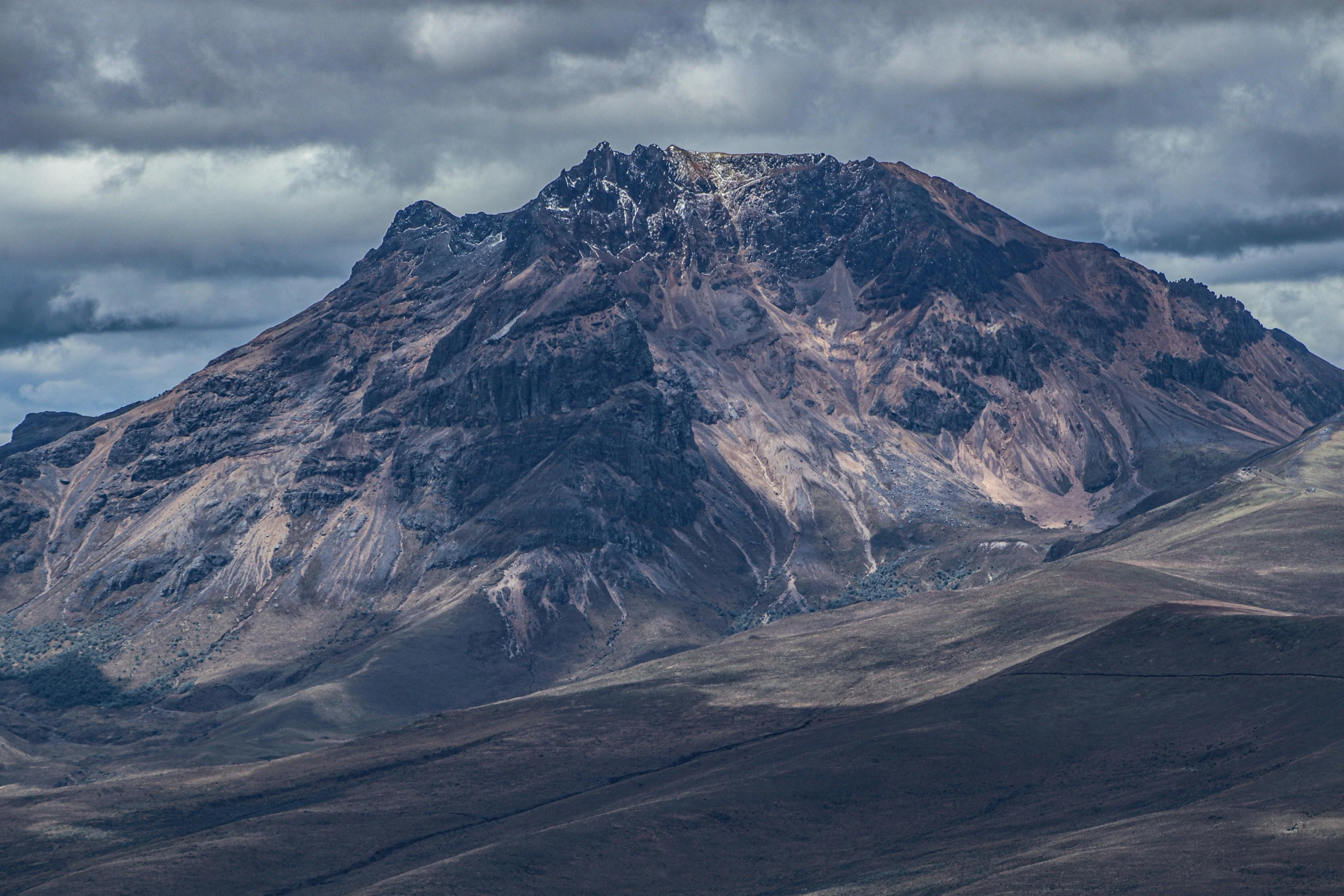 the mountains are covered in snow and brown grass