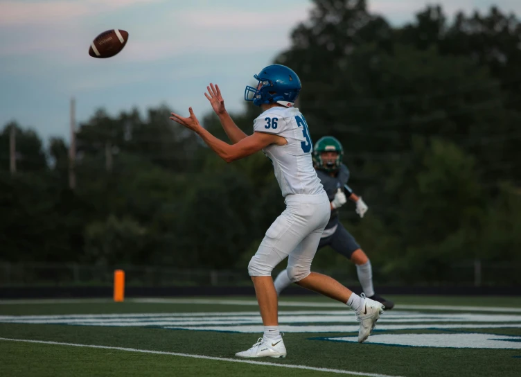 a person holding a football and leaping to catch it