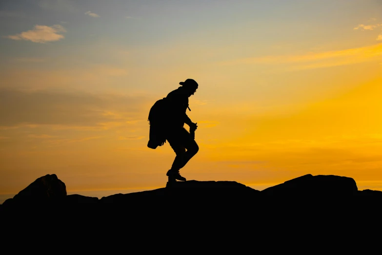 a person on top of a hill at sunset