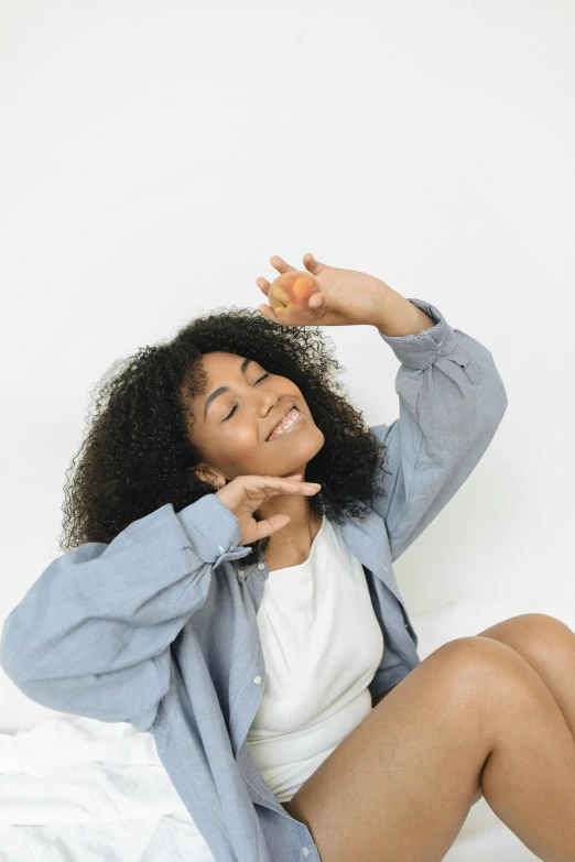 a woman is sitting on a bed with her arms spread out