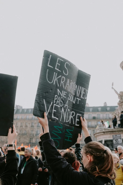 a group of people hold up signs and take pictures