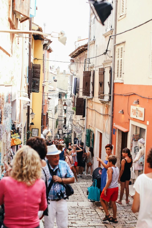 people walking down an old, narrow street