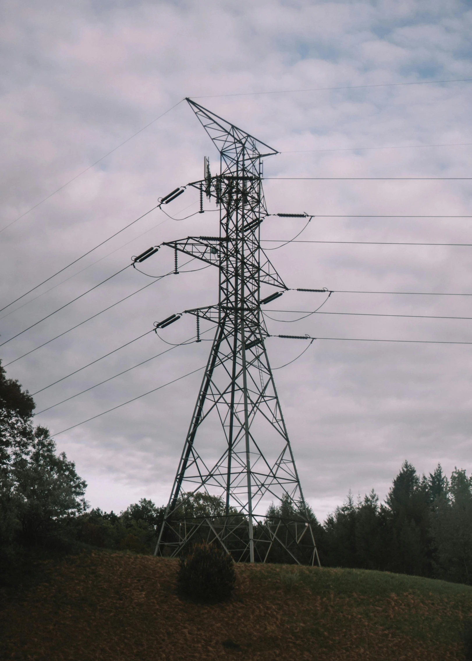 multiple poles on a hill under cloudy skies