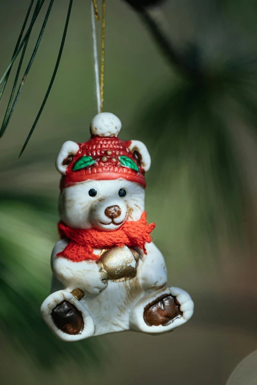 a christmas ornament hanging from a pine tree