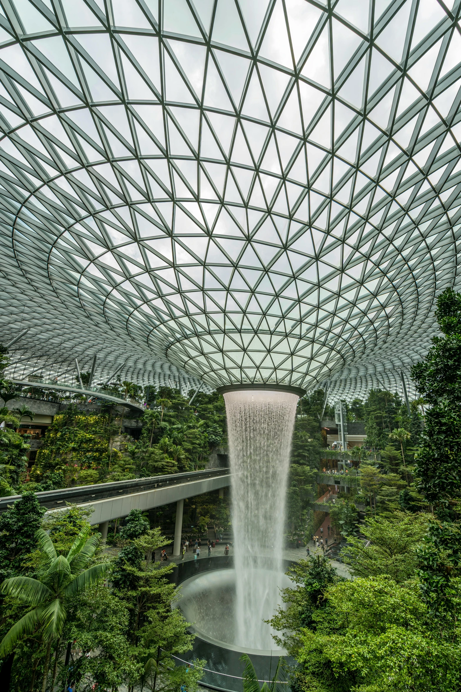 a waterfall falls into a pond in a building