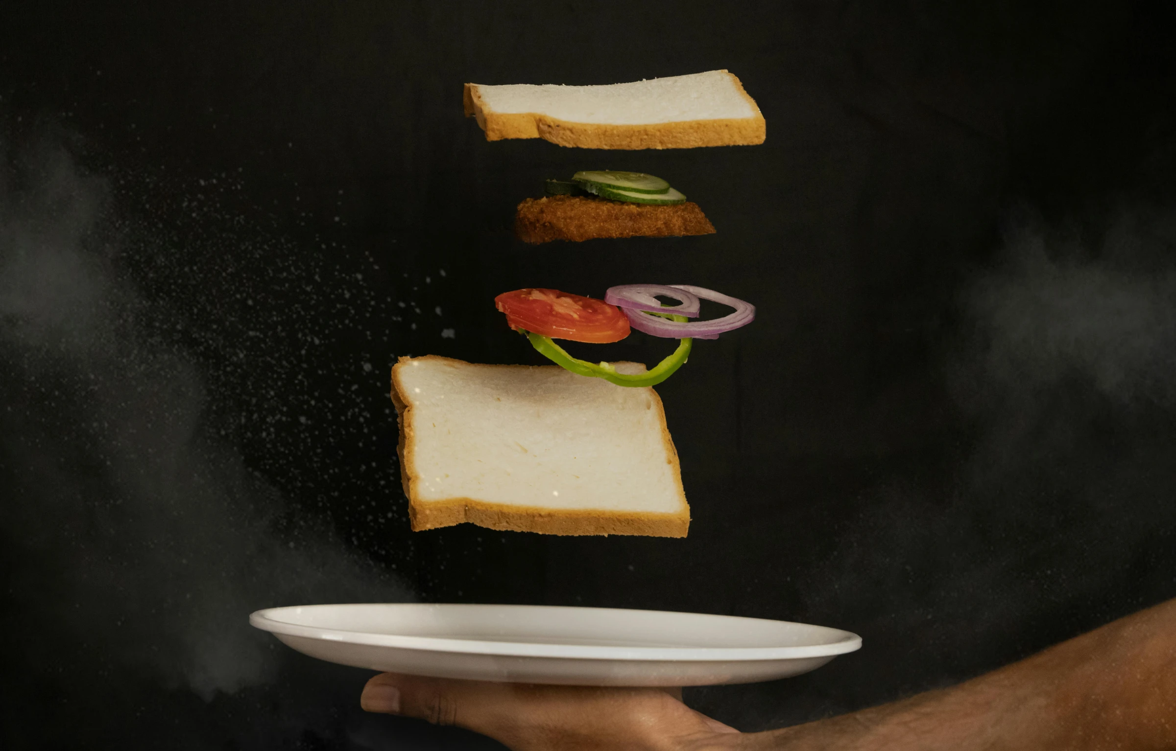 a person is holding a plate with sandwiches