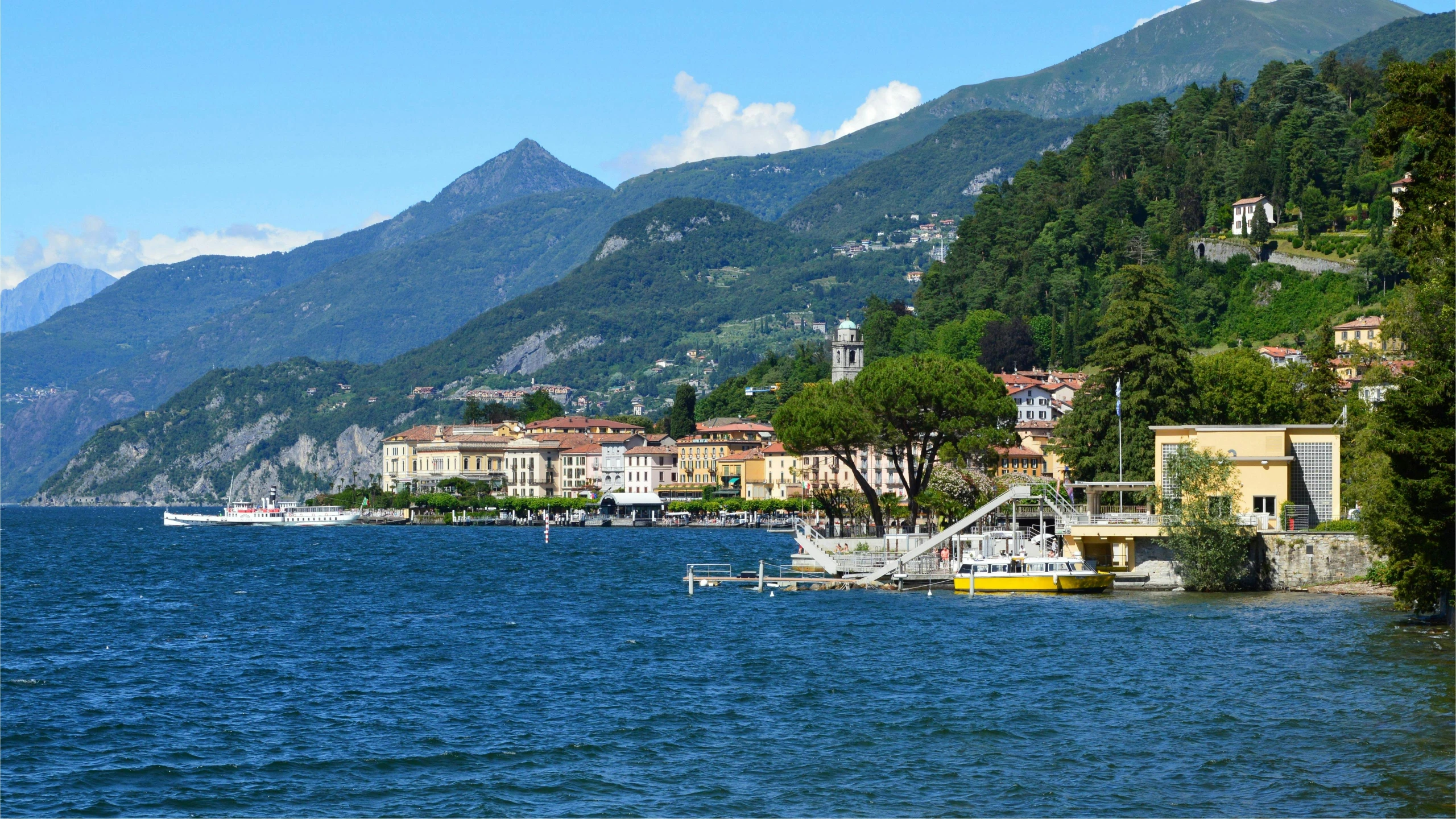 a harbor in front of many houses with mountain range in the background