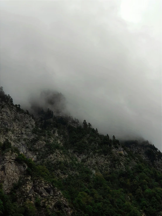 a couple of mountains with some clouds coming out of them