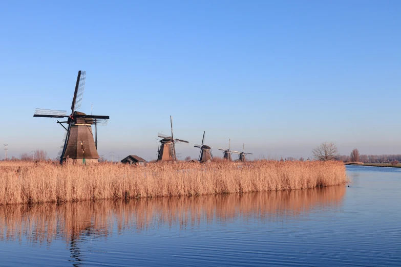 a windmill sitting on the side of a lake