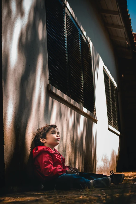 a  sitting in the shade, looking up