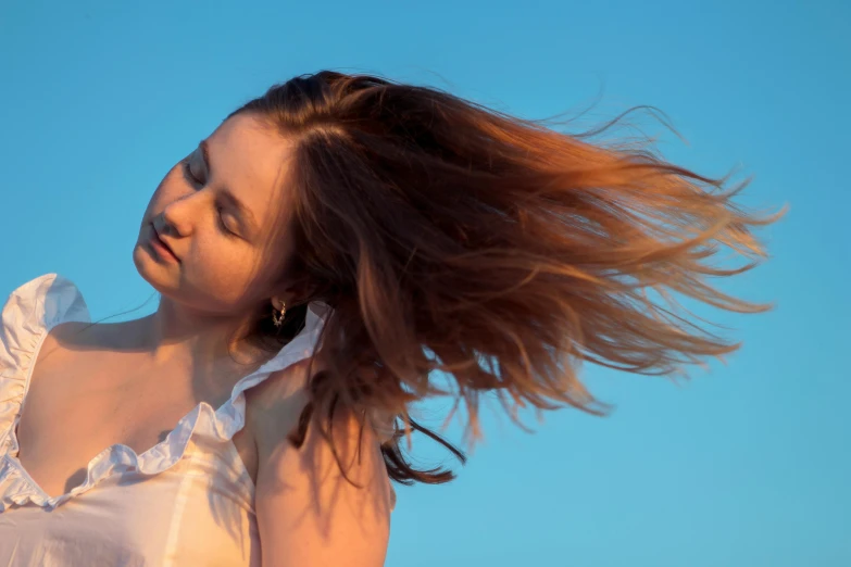 a woman in white dress holding onto a phone