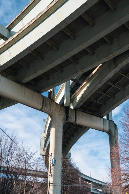 a street sign is under a road bridge