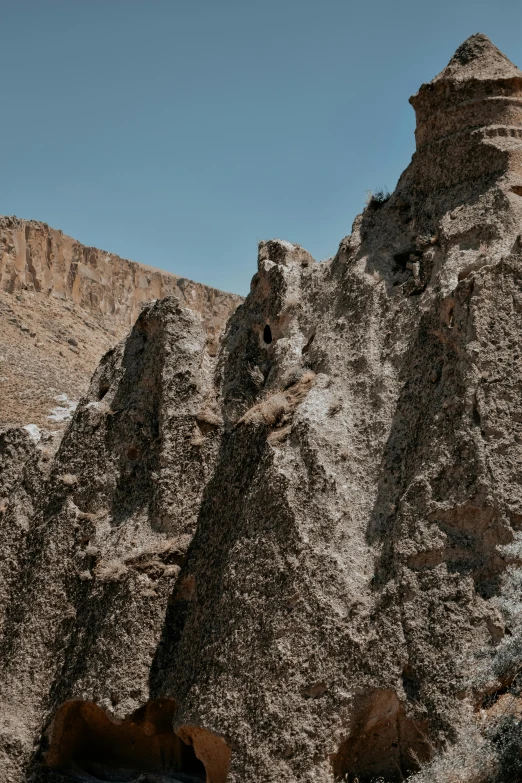 a mountain with a rocky cliff face and two brown bears