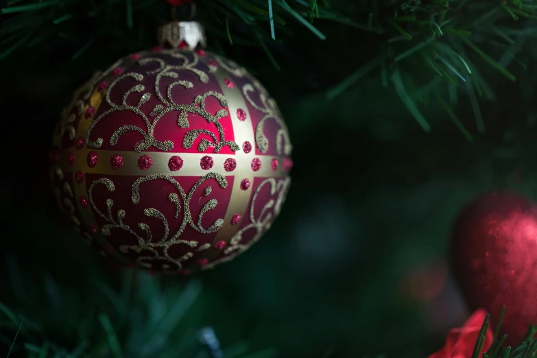 the red and gold ornament has been hanging on the christmas tree