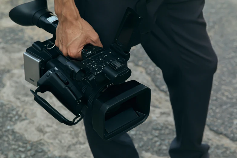 a man holding two camera accessories on his left hand