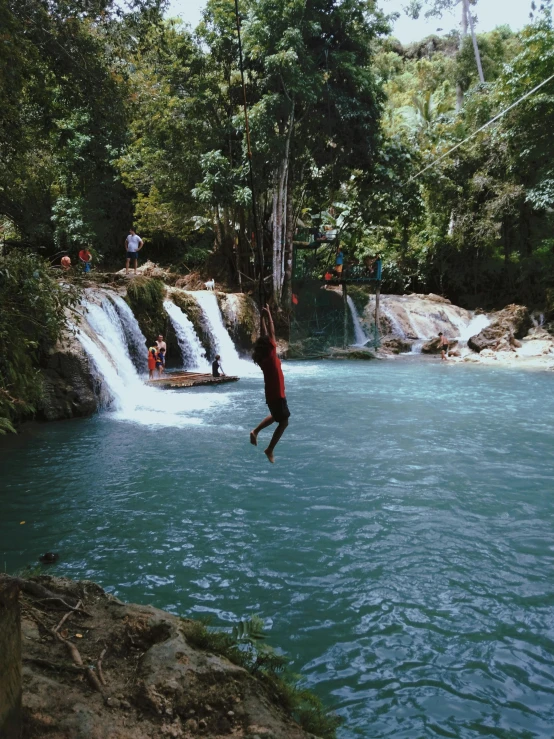 a man is hanging above the water falling in