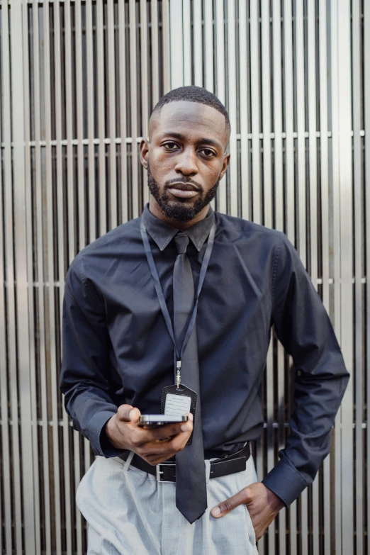 a man in a business suit standing next to a metal fence