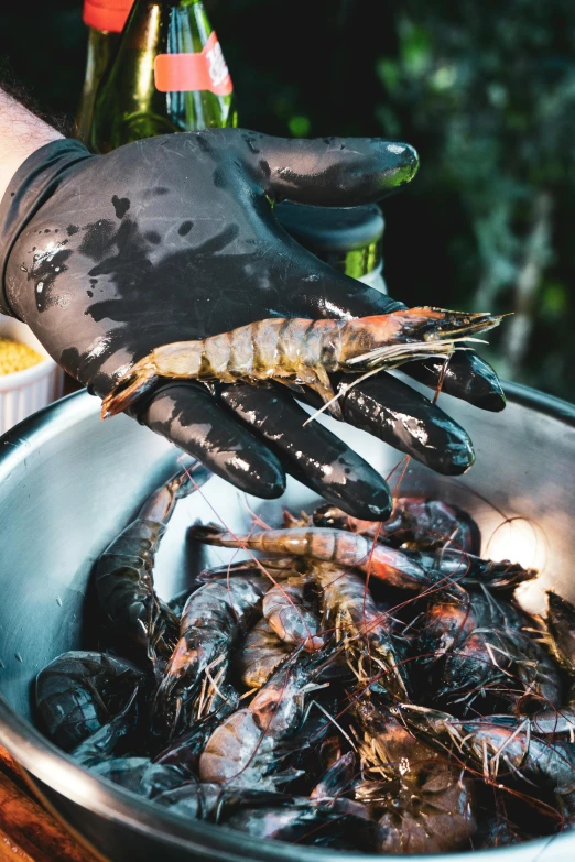 some black crawfish are in a bowl and some beer