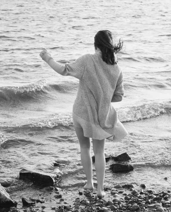 a woman is flying her kite on the shore