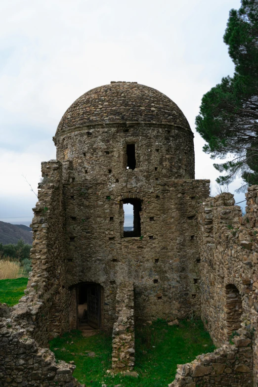 a small stone building sitting on top of green grass