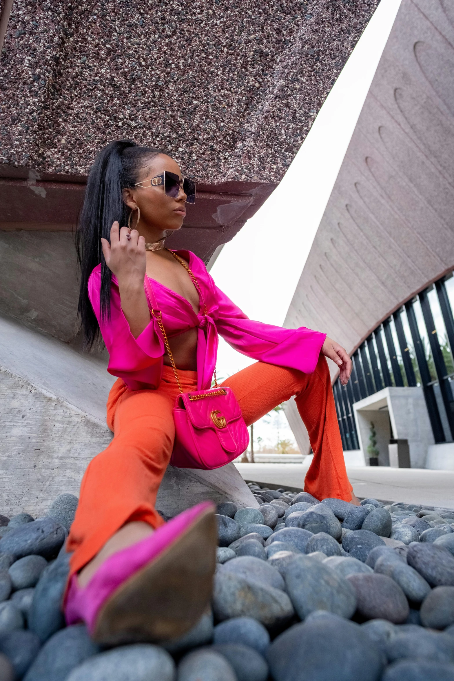 a woman sitting on a rock posing for a po