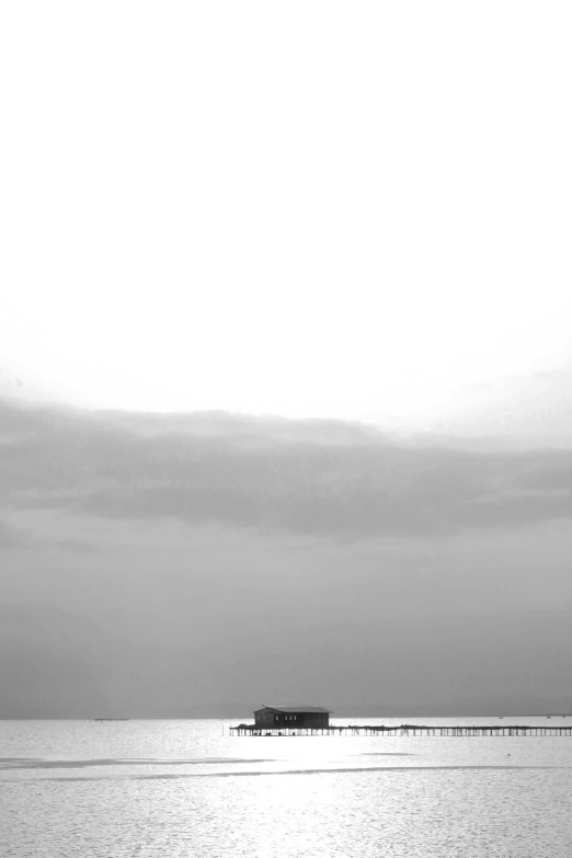 a large body of water with a small pier in the distance