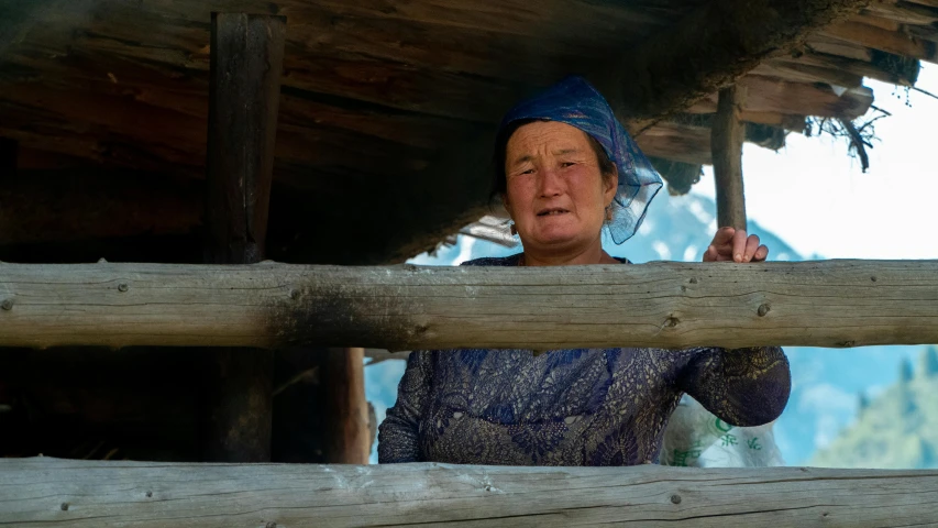 an old woman is standing at a structure