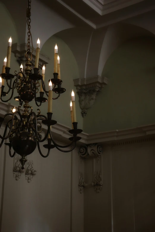 a chandelier has eight candles lit by two chandeliers