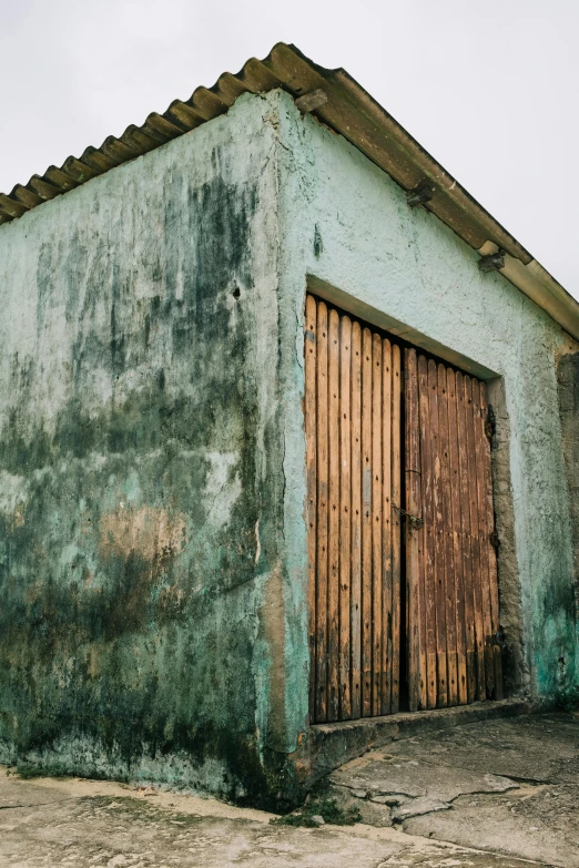 an old garage has been painted green and brown