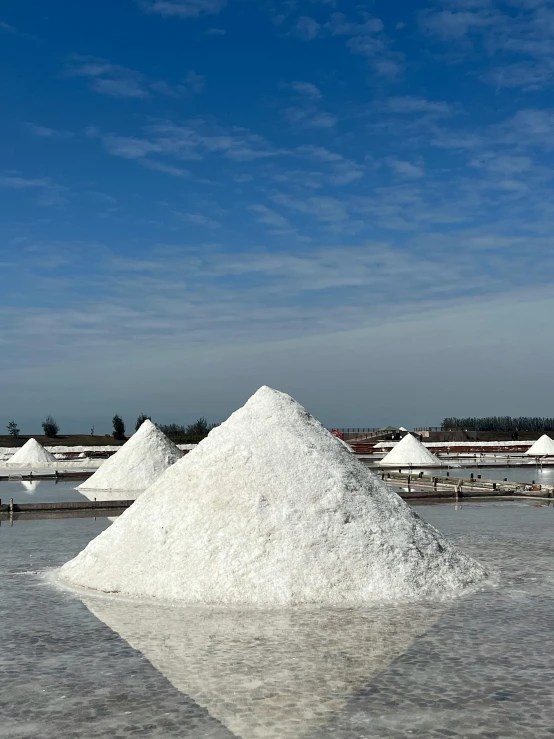 some very large piles of white sand on a beach