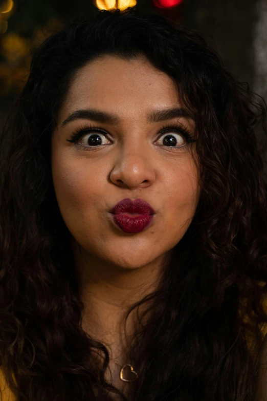 young woman making funny face in dim lighting