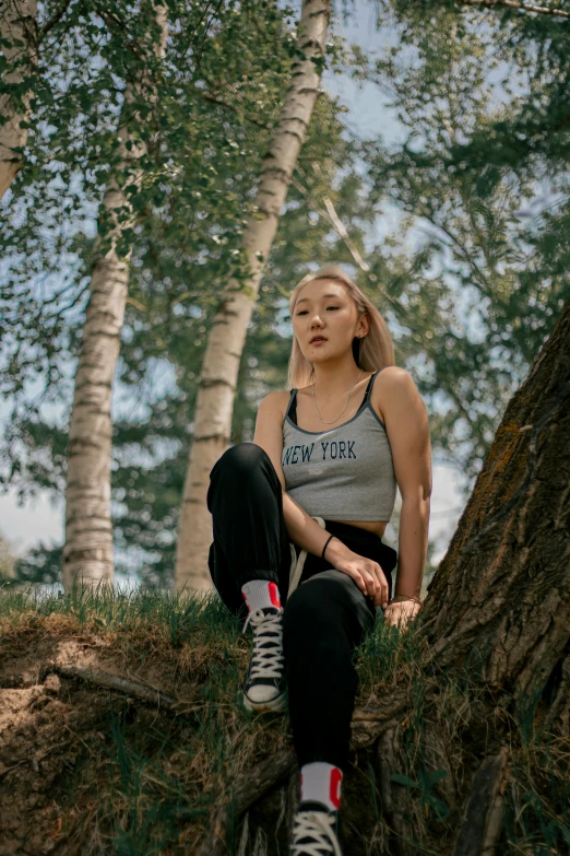 a woman sitting on top of a tree trunk