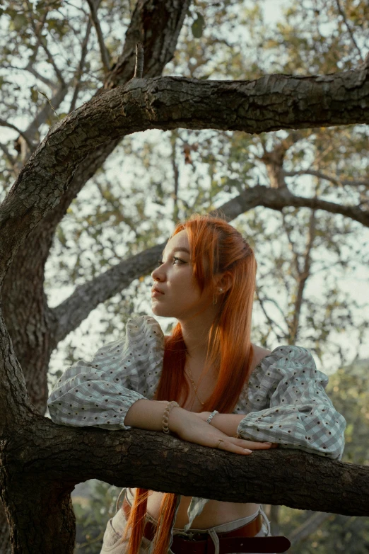 a woman sitting on top of a tree nch looking over