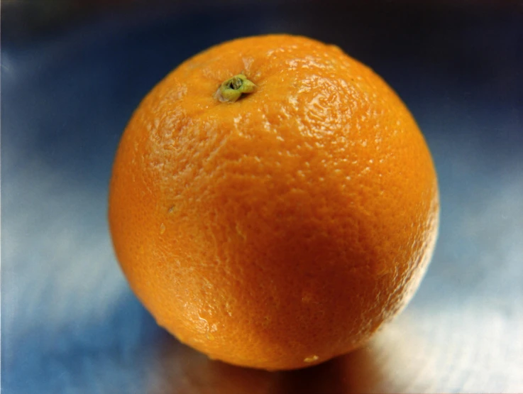 an orange sitting on top of a blue table
