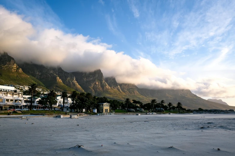 a beach is lined with houses and some trees