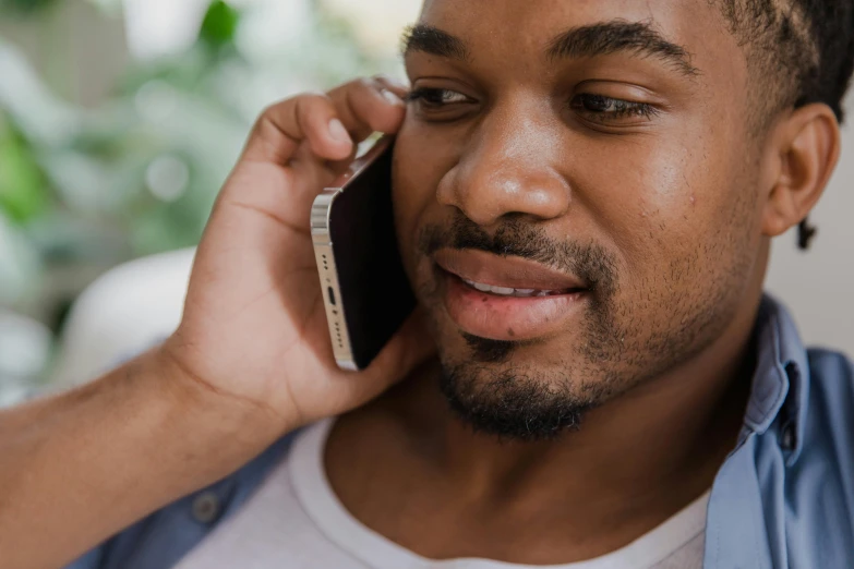 an african american man holding a cellular phone to his ear