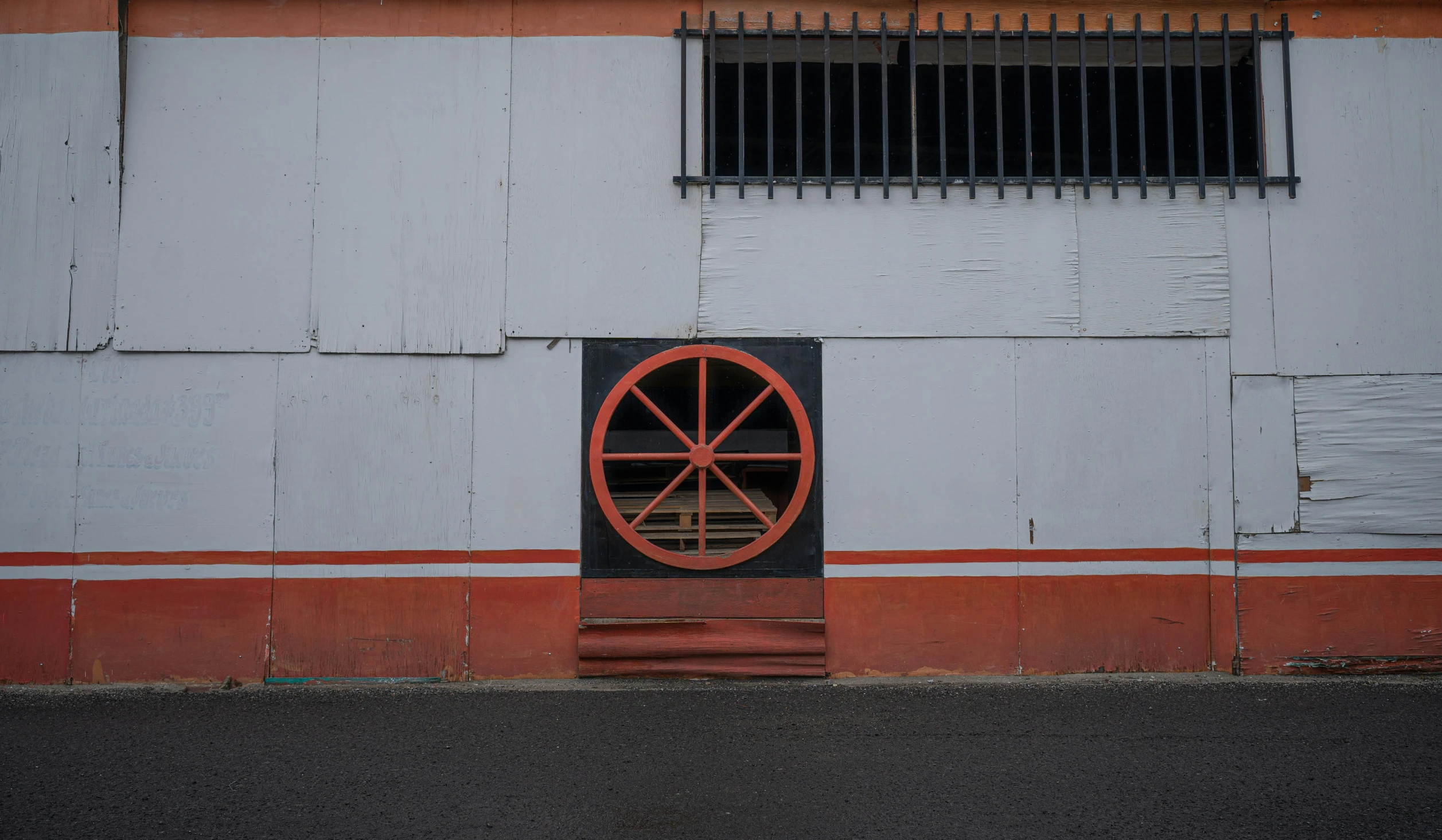 a building is painted white with a red wheel