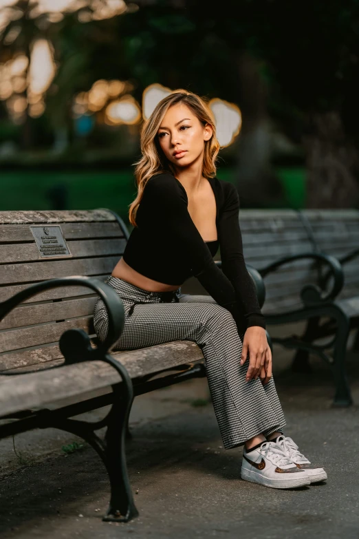 a woman sitting on top of a wooden bench