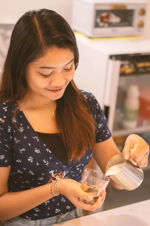 a woman is pouring a cup of water with her right hand