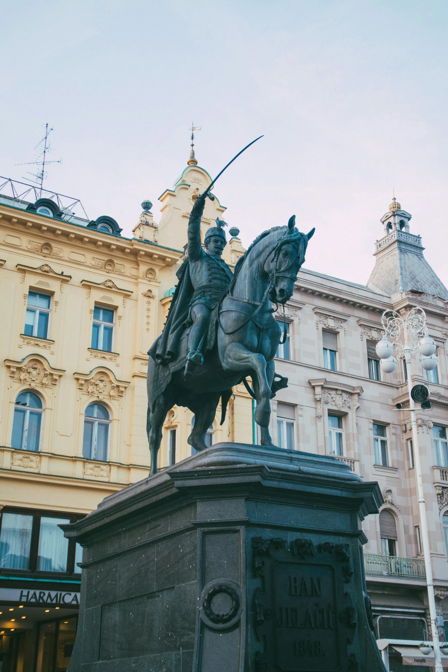 a statue on the corner of a street in front of a building