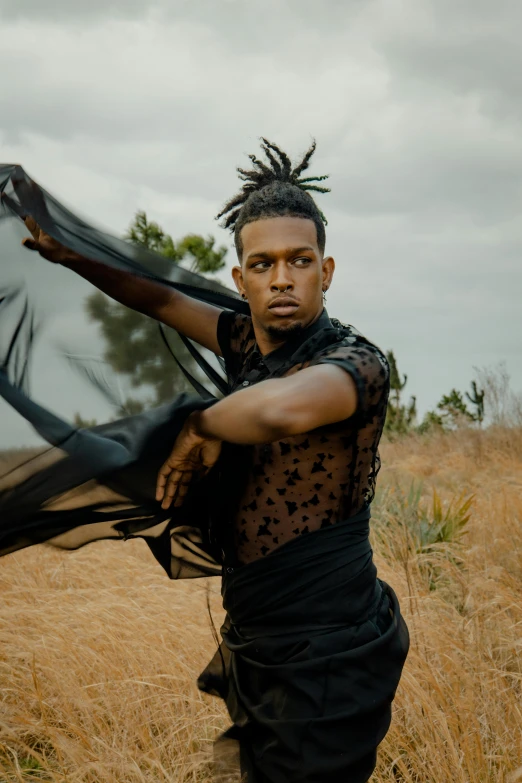 a man standing in a field with a scarf