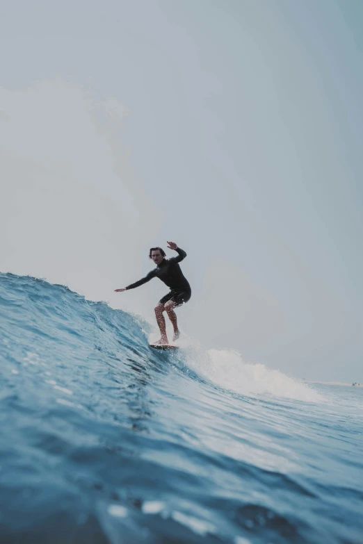 a man in a wetsuit is riding a surfboard