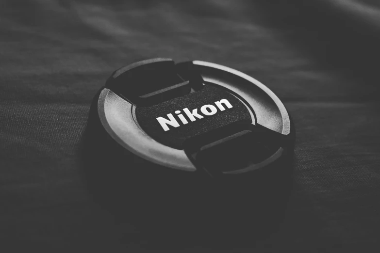 black and white pograph of a nikn camera lens cap