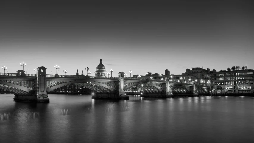 the bridge is crossing over the water in front of many buildings